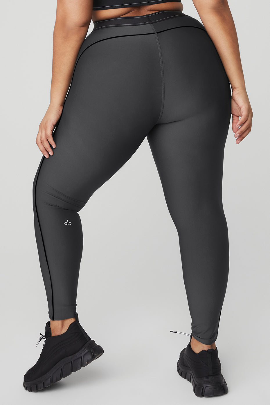 A woman wearing Airlift High-Waist Suit Up Legging with body-contouring piping and boxer-style waistband from the back.
