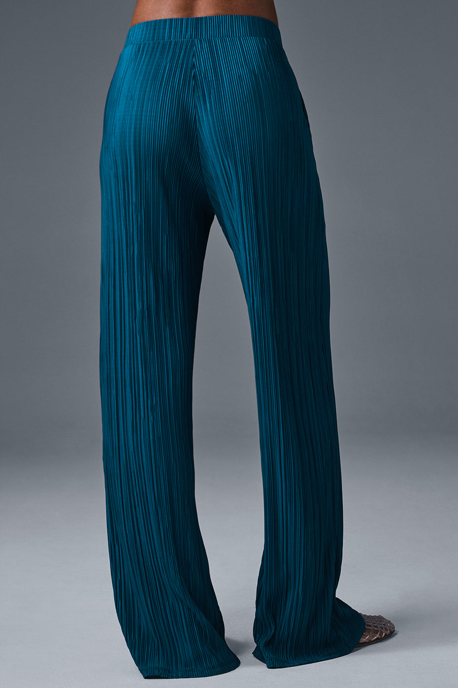 Back view of high-waist micro plisse straight leg pant in teal showcasing soft mini-pleat texture and relaxed fit.