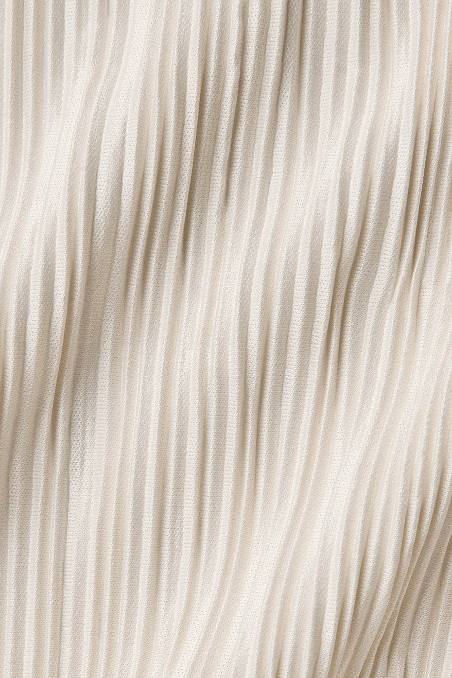 Close-up of soft micro plisse fabric featuring a crinkly mini-pleat texture in a light cream color.