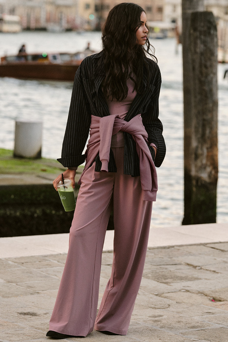 Model showcasing the High-Waist Dreamscape Trouser in a stylish outfit by the waterfront.