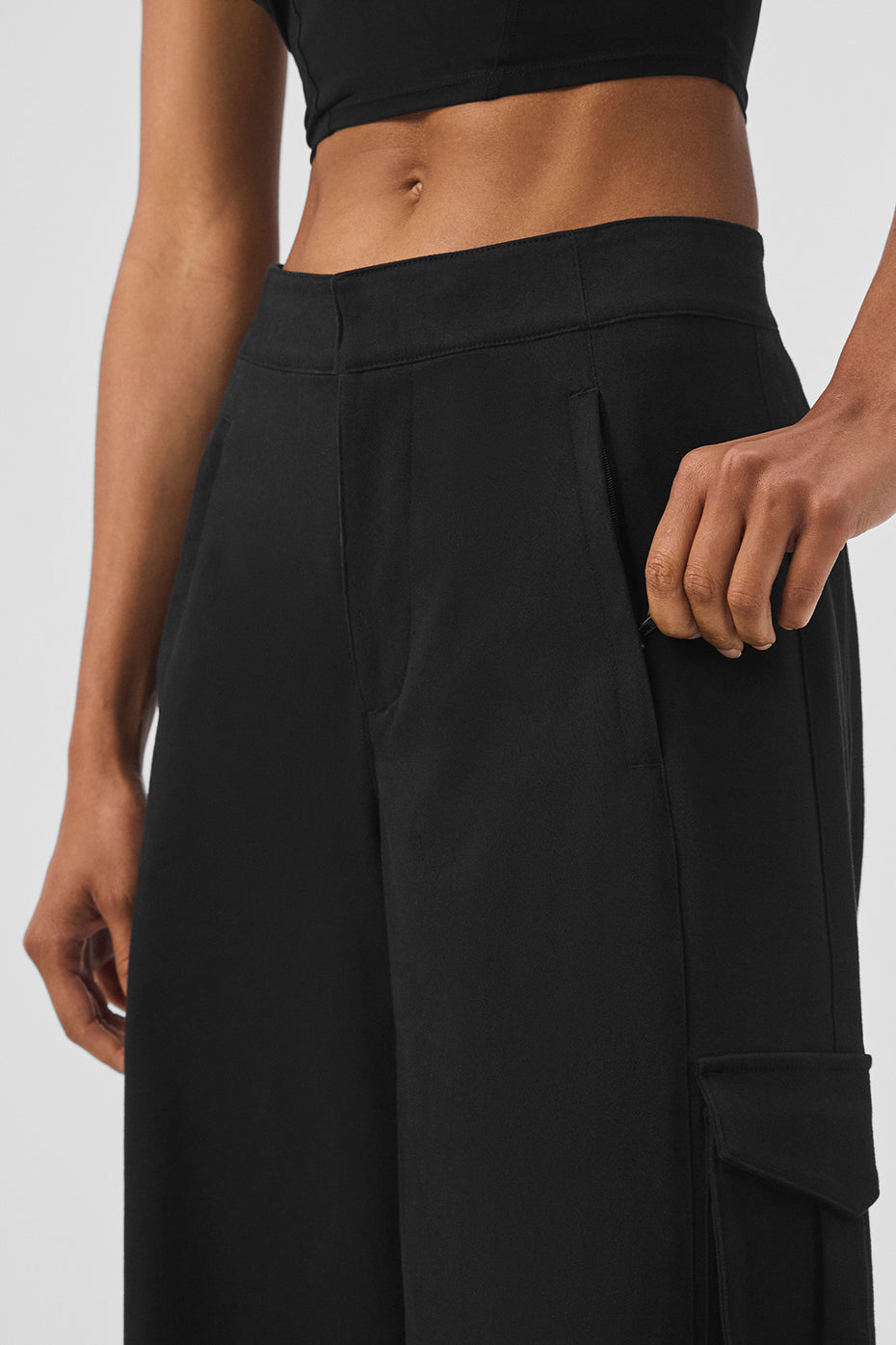 Close-up of high-waisted, black cargo wide leg trouser featuring front zipper pockets and exaggerated wide legs.