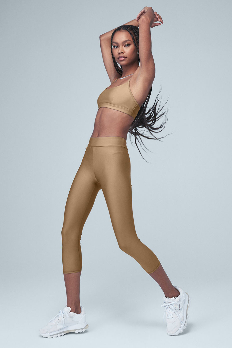 Model wearing Airlift High-Waist Conceal-Zip Capri with sporty top and sneakers, showcasing a stylish activewear look.
