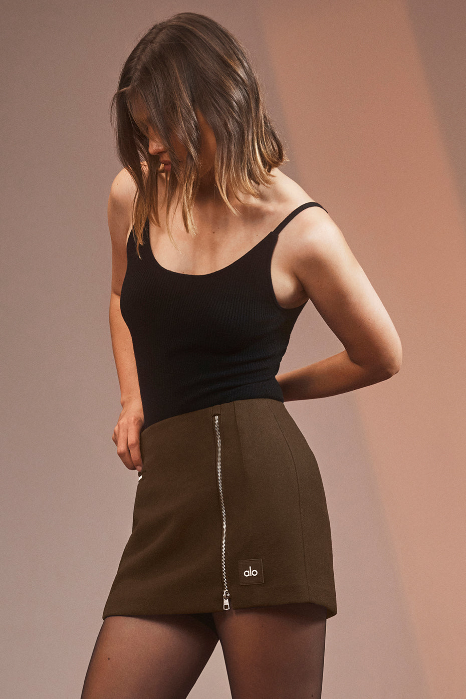 Model wearing a Winter Wool Vendome Mini Skirt styled with a black tank top, showcasing functional zippers and an A-line silhouette.
