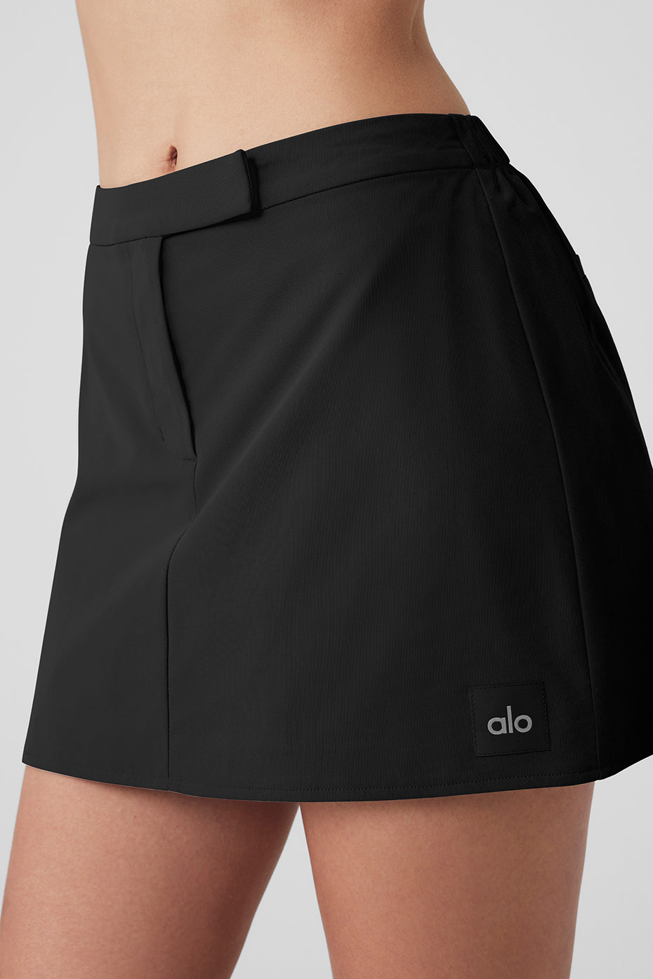 High Speed Mini Skirt in black with tailored fit and faux welt pockets showcasing smooth, structured fabric.