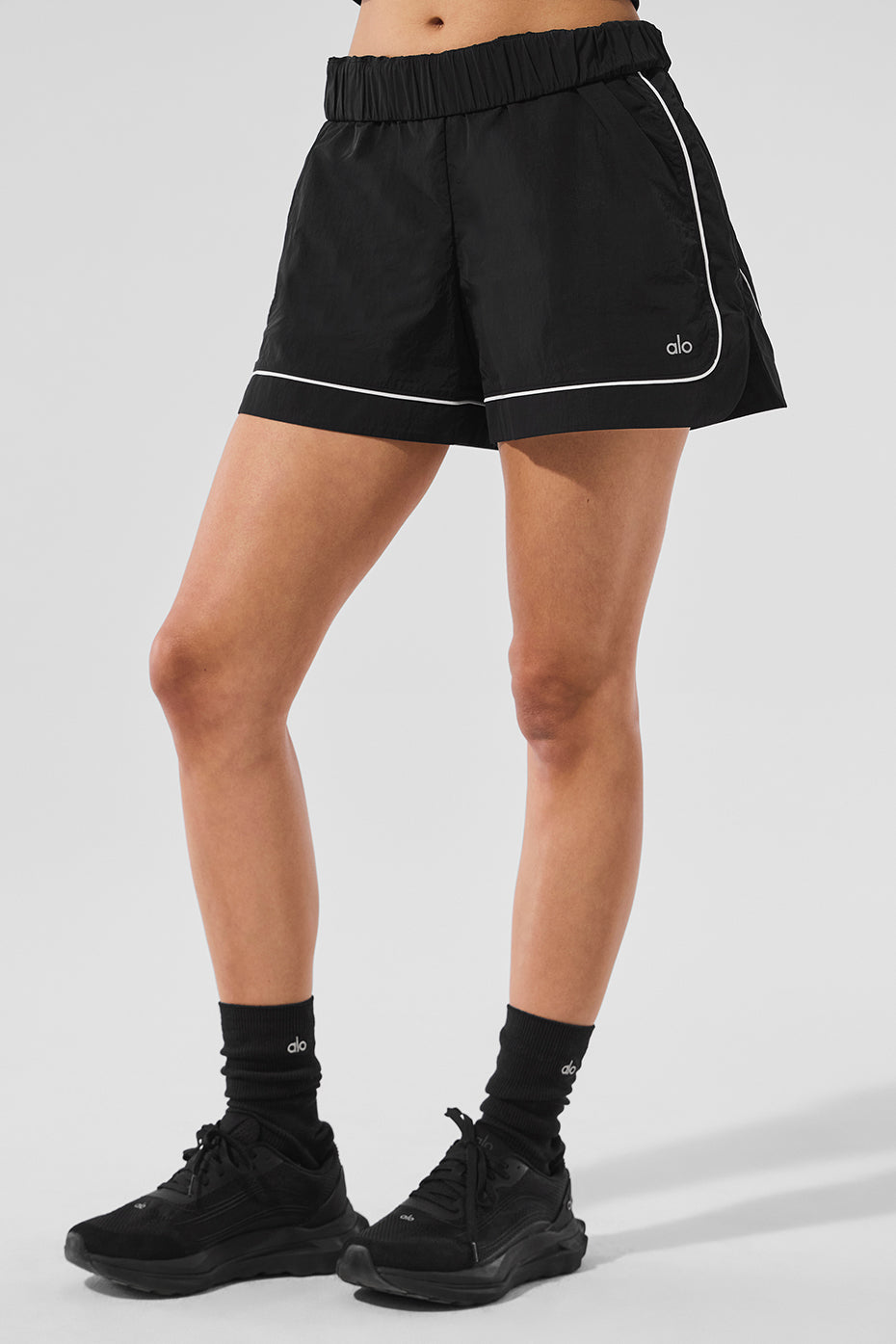 Motivate Track Short featuring contrast piping, zippered pockets, and a sporty chic design for performance and style.