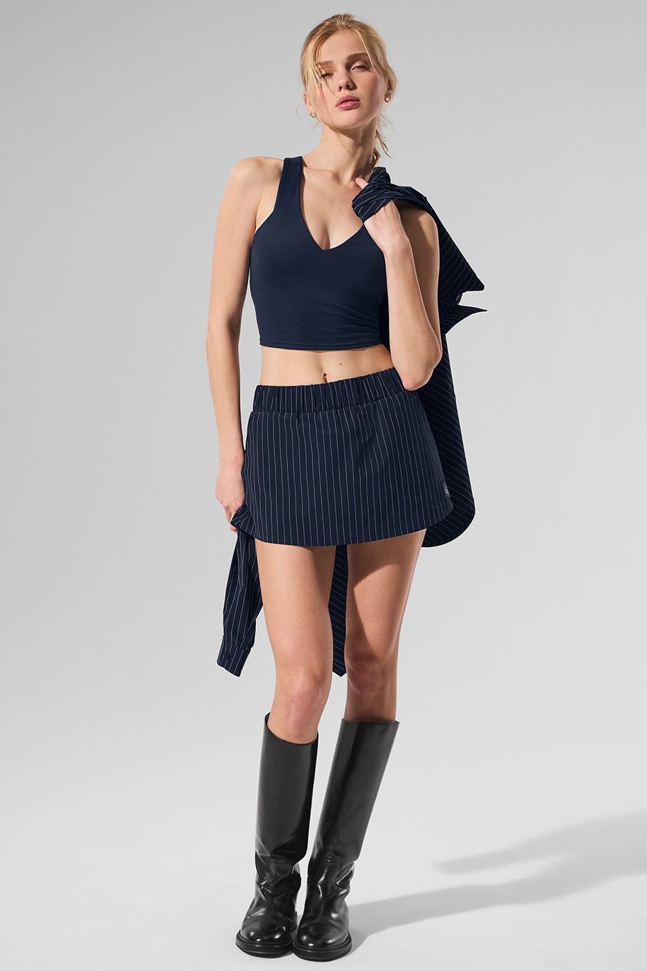 Model wearing a navy Pinstripe Daylight Mini Skirt with built-in shorts and a coordinating top for a stylish look.