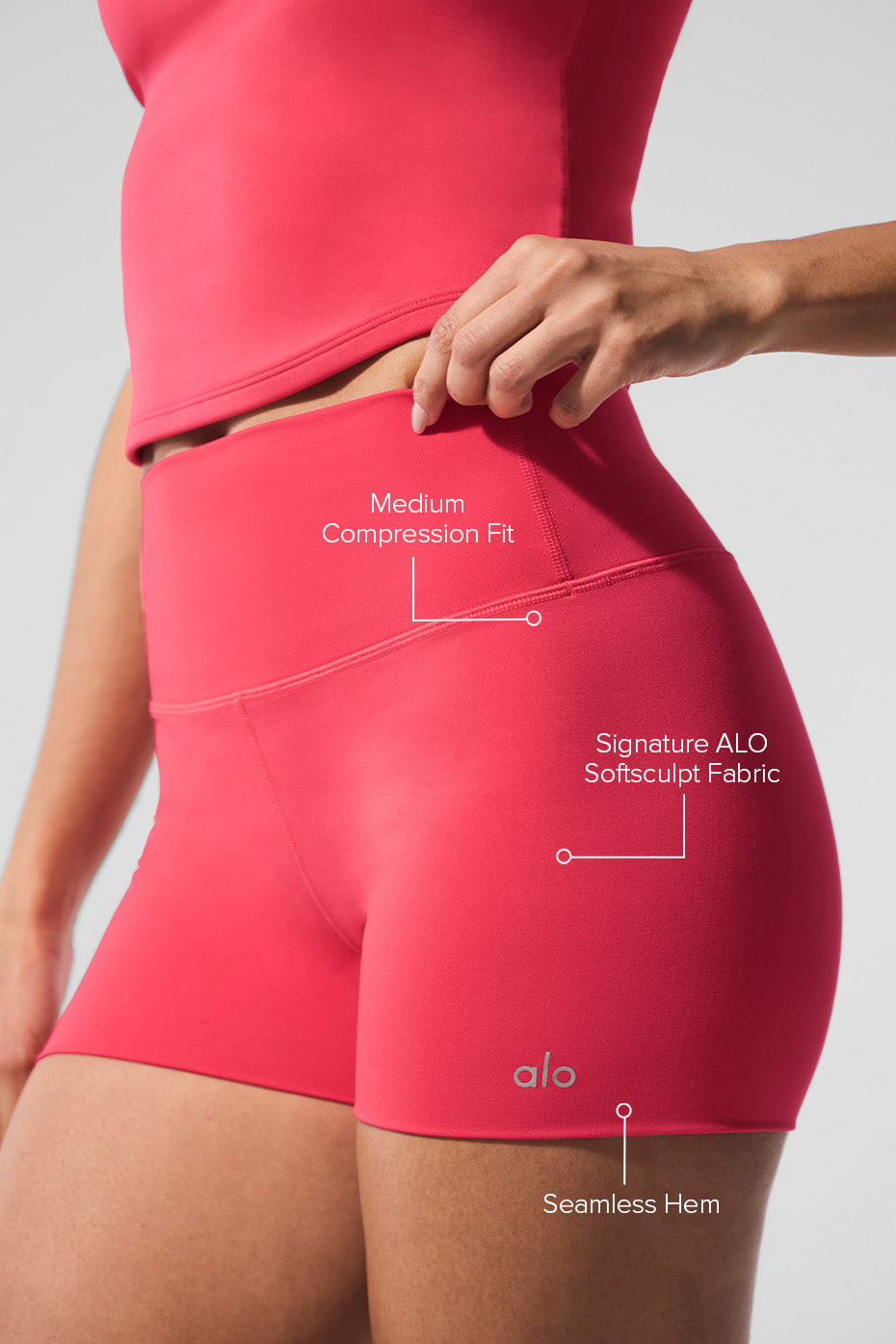 Female model showcasing ALO Softsculpt High-Waist Precision Short with medium compression fit and seamless hem in pink.