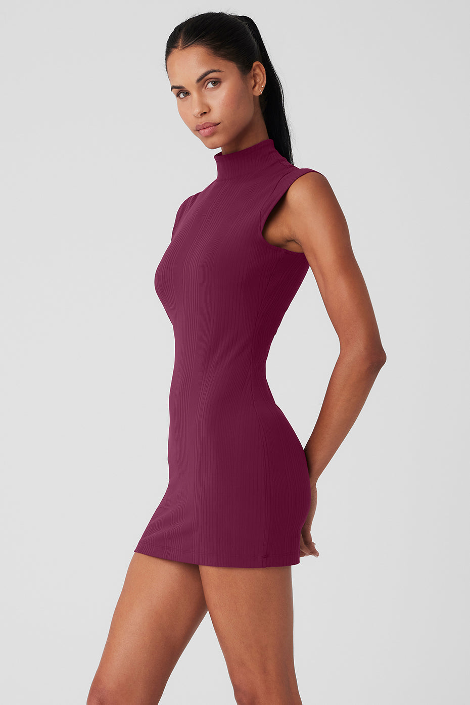 Model wearing a burgundy Run It Back Dress with a mock neck and sleeveless design, showcasing a curve-defining fit.