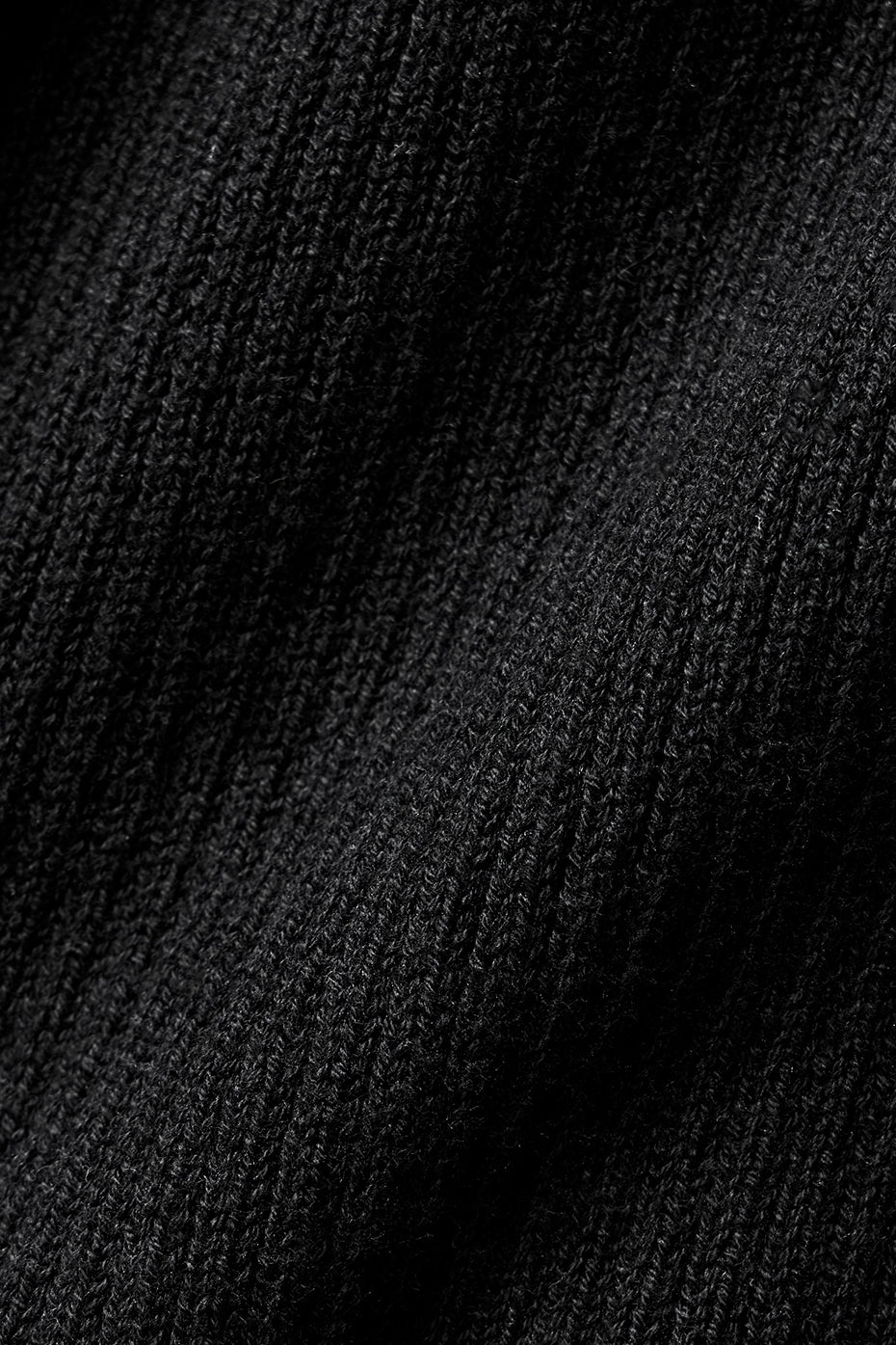 Close-up of the black fabric texture of the Supernatural Sweater Dress, showcasing its lightweight knit.