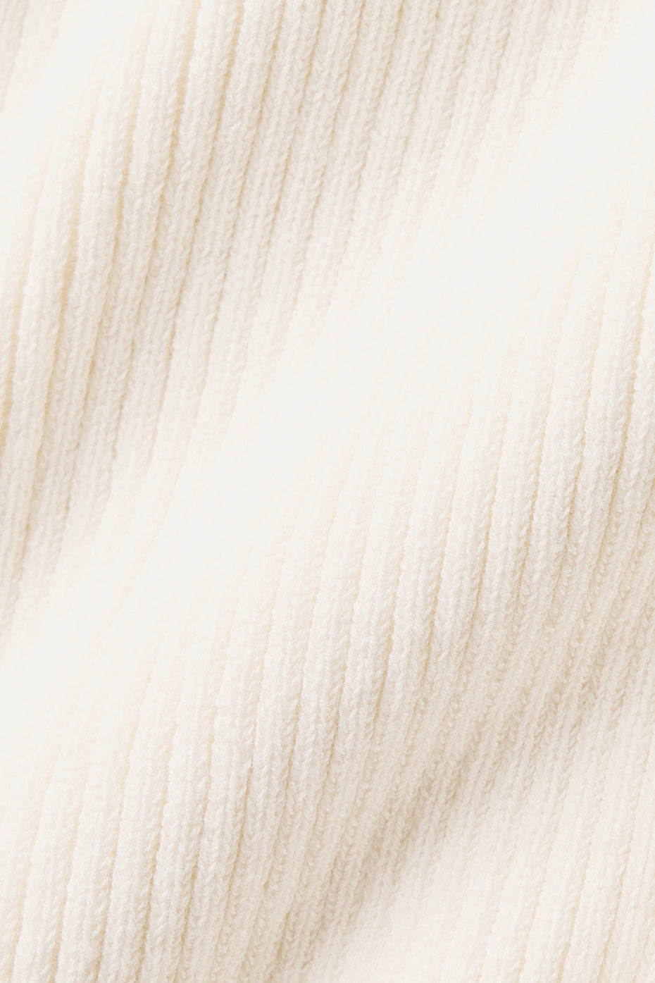 Close-up of lightweight knit fabric in creamy white, ideal for a Supernatural Sweater Dress, offering breathability and style.