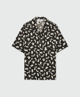 Black poplin bowling shirt with Follow the Rabbit print, short-sleeved, oversized fit, featuring a chest pocket.
