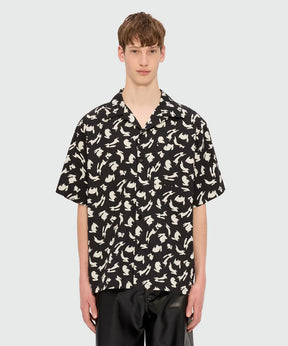 Black poplin bowling shirt with Follow the Rabbit print on model featuring oversized fit and chest pocket.
