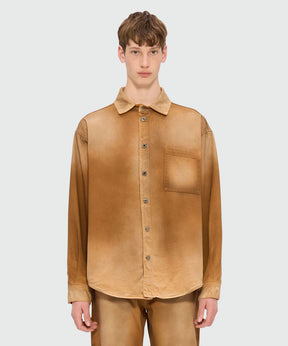 Beige spray-effect denim shirt with classic collar and front button closure, featuring chest pocket and oversized fit.