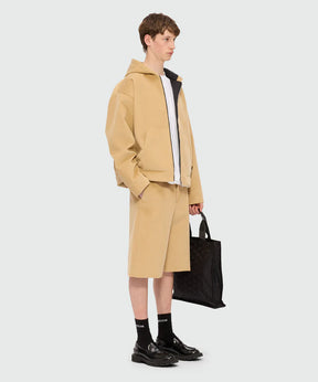 Beige hooded jacket in scubbato velvet with kangaroo pockets and oversized fit, worn by a model with shorts.