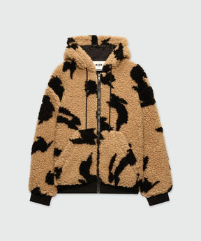 Beige teddy jacket with black motifs, drawstring hood, front zip closure, and kangaroo pockets.