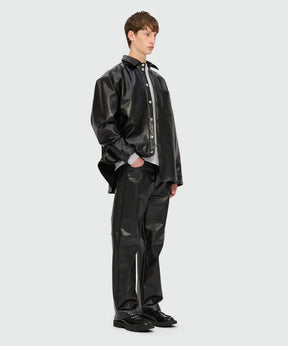 Black faux leather shirt and pants outfit modeled by a young man in a stylish pose with a modern aesthetic.