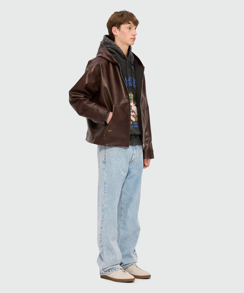 Model wearing black marbled jersey hoodie with 'Family Business' print under a brown leather jacket, featuring relaxed jeans.