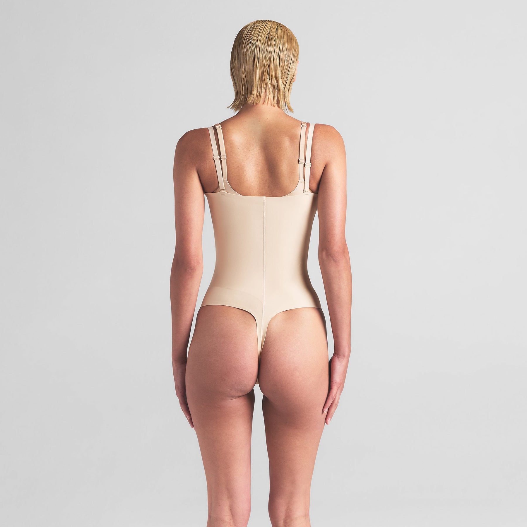 SKIMS BODY CORE SCULPT OPEN BUST THONG BODYSUIT | SAND