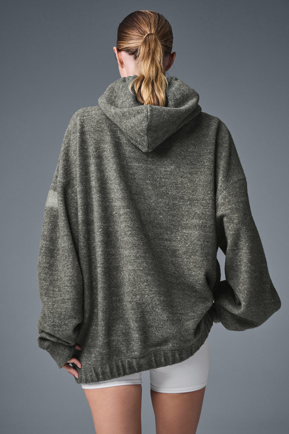 Back view of the Triumph Hoodie in soft fleece with a hood, showcasing its comfortable and relaxed fit.