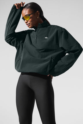 Lightweight Takeaway Track Pullover in black with quarter-zip neck, relaxed fit, and zippered pockets, styled with leggings.