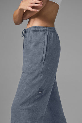 Model wearing Chill Vintage Wash Sweatpant in faded blue with stretchy drawstring waist and side pockets.