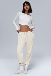 Model wearing Chill Sweatpant with a white crop top, showcasing breathable fabric and side pockets.