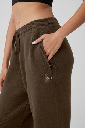 Close-up of scholar straight leg sweatpants showing exterior drawcord and zippered pocket in a soft knitted fabric.