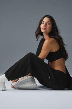 Model wearing Triumph Restore Sweatpant in black, showcasing the relaxed fit and soft fleece fabric.