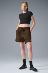 Model wearing 7 inch crinkle nylon excursion cargo shorts with drawstring waist and cargo pockets, styled for an active look.