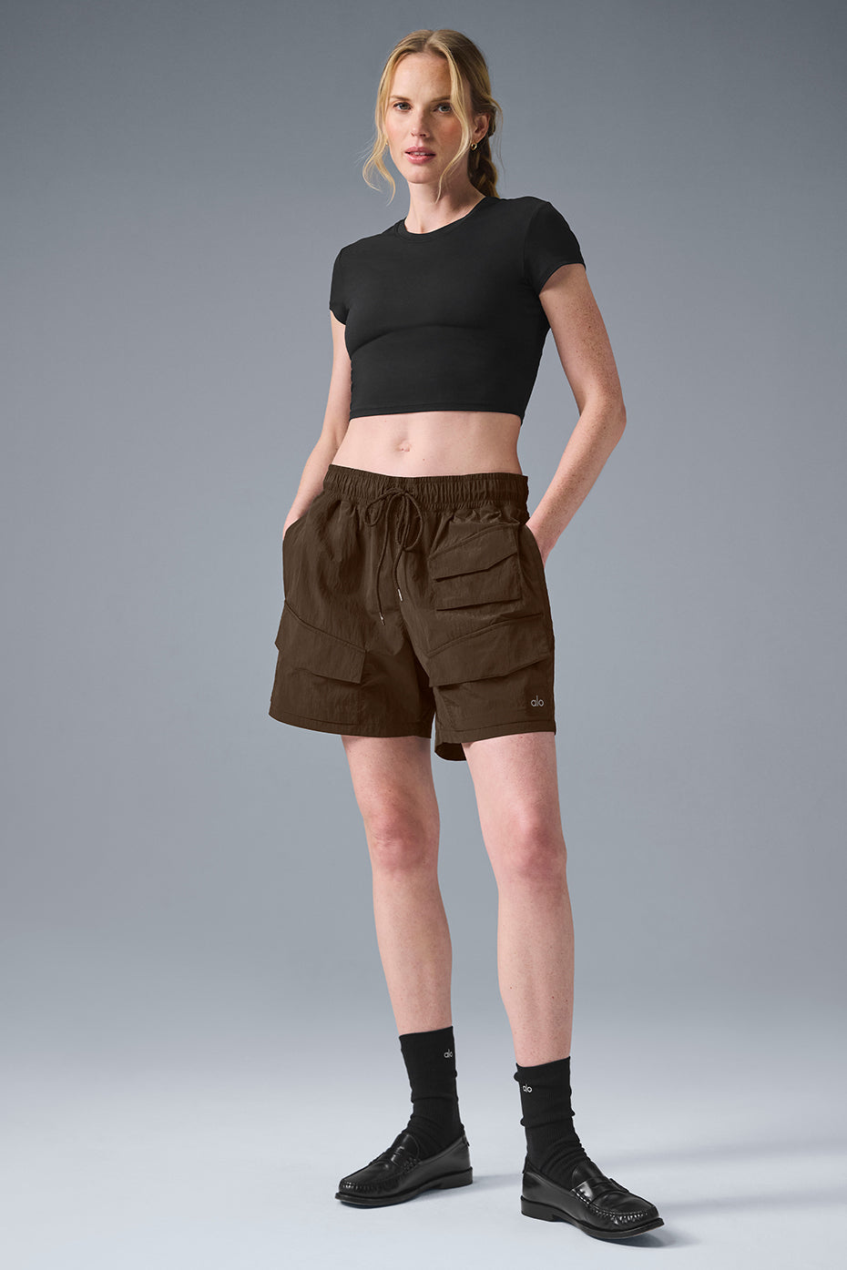 Model wearing 7 inch crinkle nylon excursion cargo shorts with drawstring waist and cargo pockets, styled for an active look.