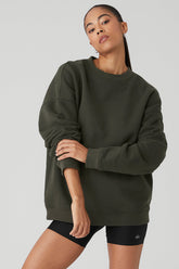 Model wearing Renown Heavy Weight Crew Neck Pullover in dark green, showcasing oversized fit and dropped shoulders.