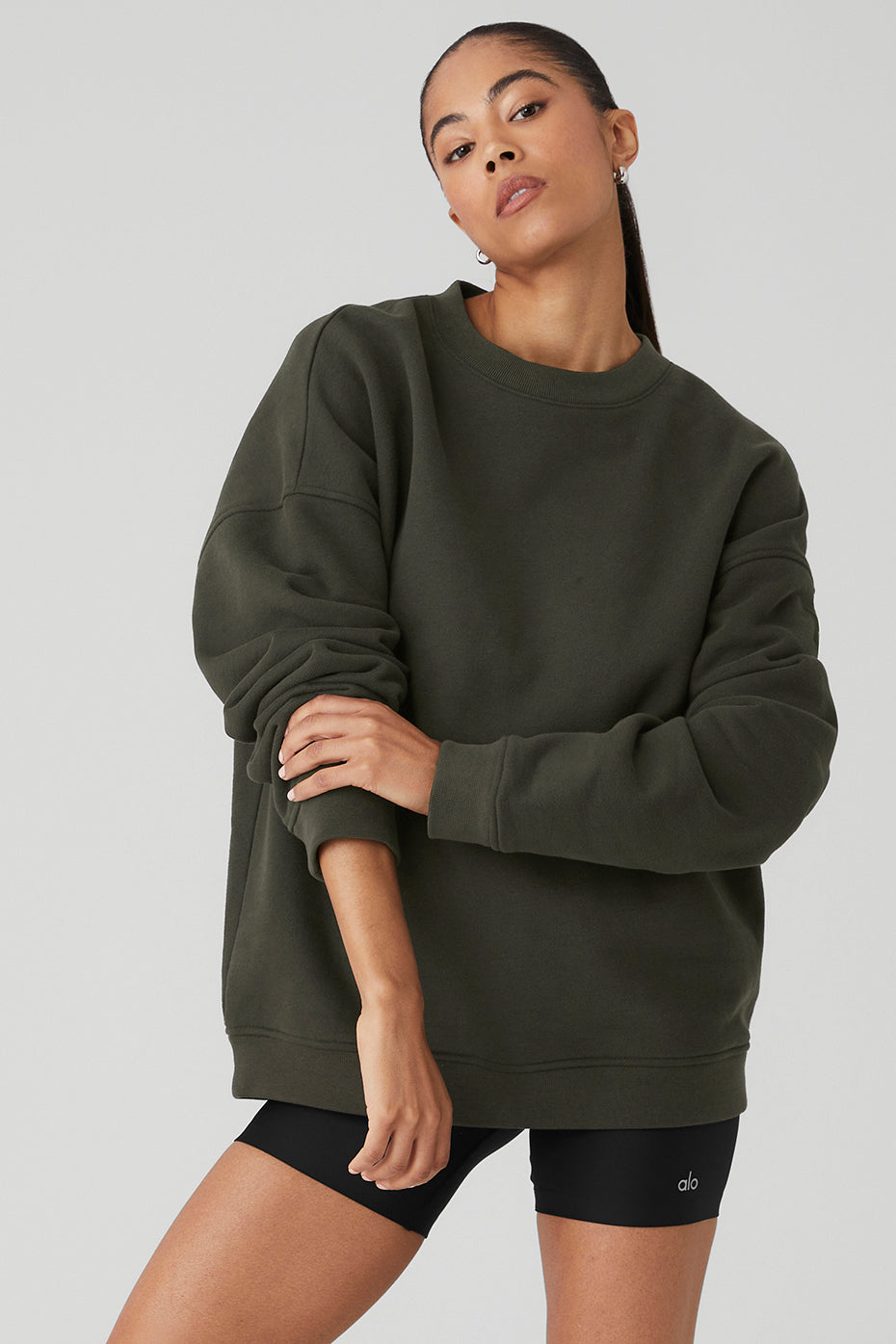 Model wearing Renown Heavy Weight Crew Neck Pullover in dark green, showcasing oversized fit and dropped shoulders.