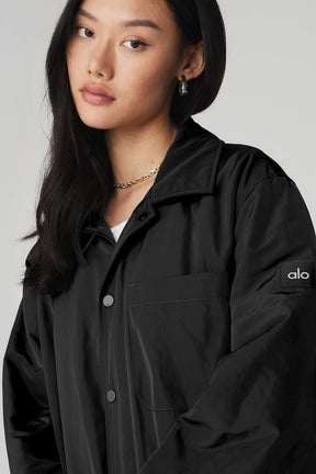 Woman wearing the Legend Jacket in black featuring sleek nylon lining, front buttons, and an iconic collar.
