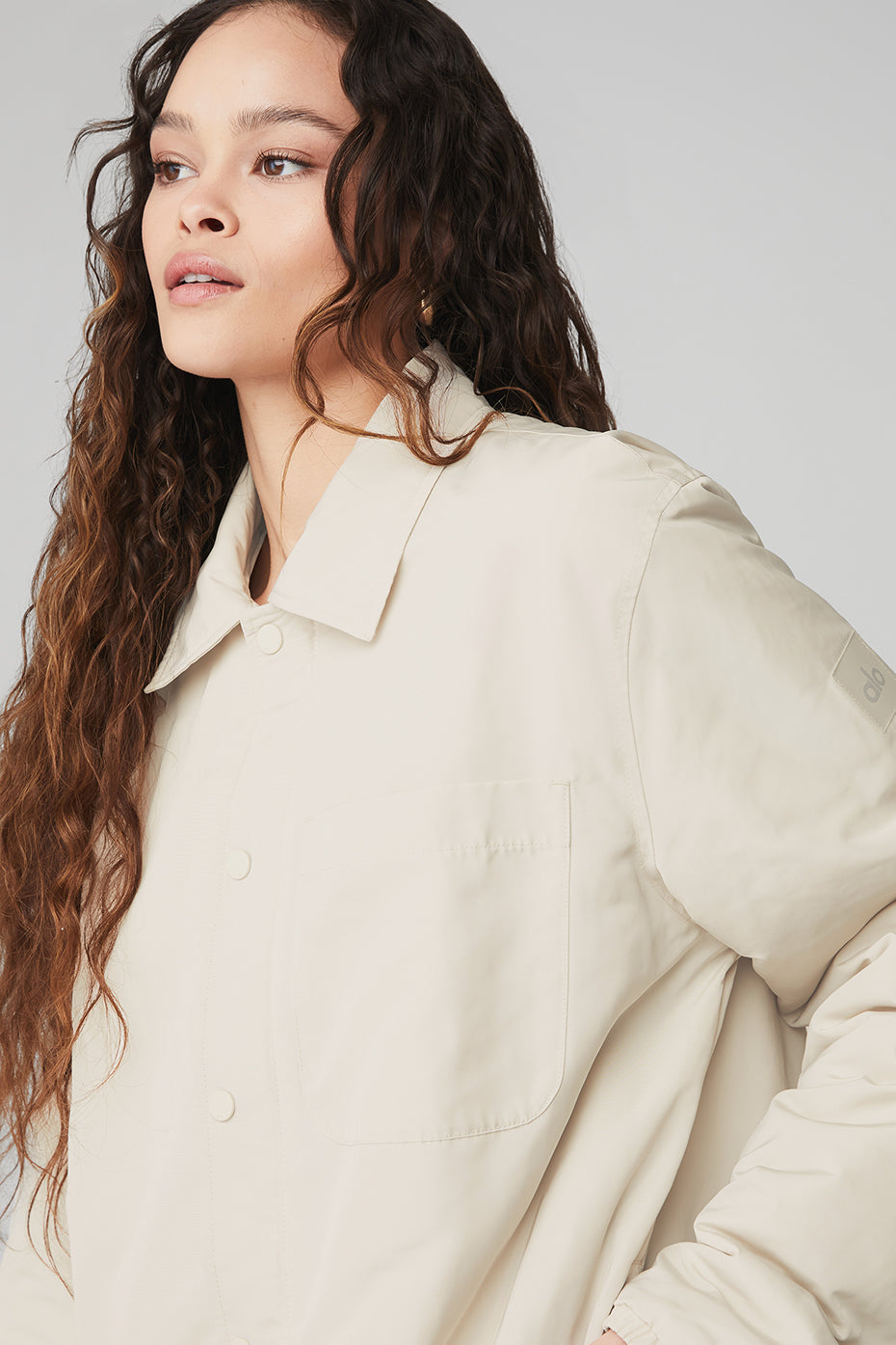 Woman wearing the Legend Jacket, a lightweight jacket with a collar and front pocket, showcasing style and comfort.