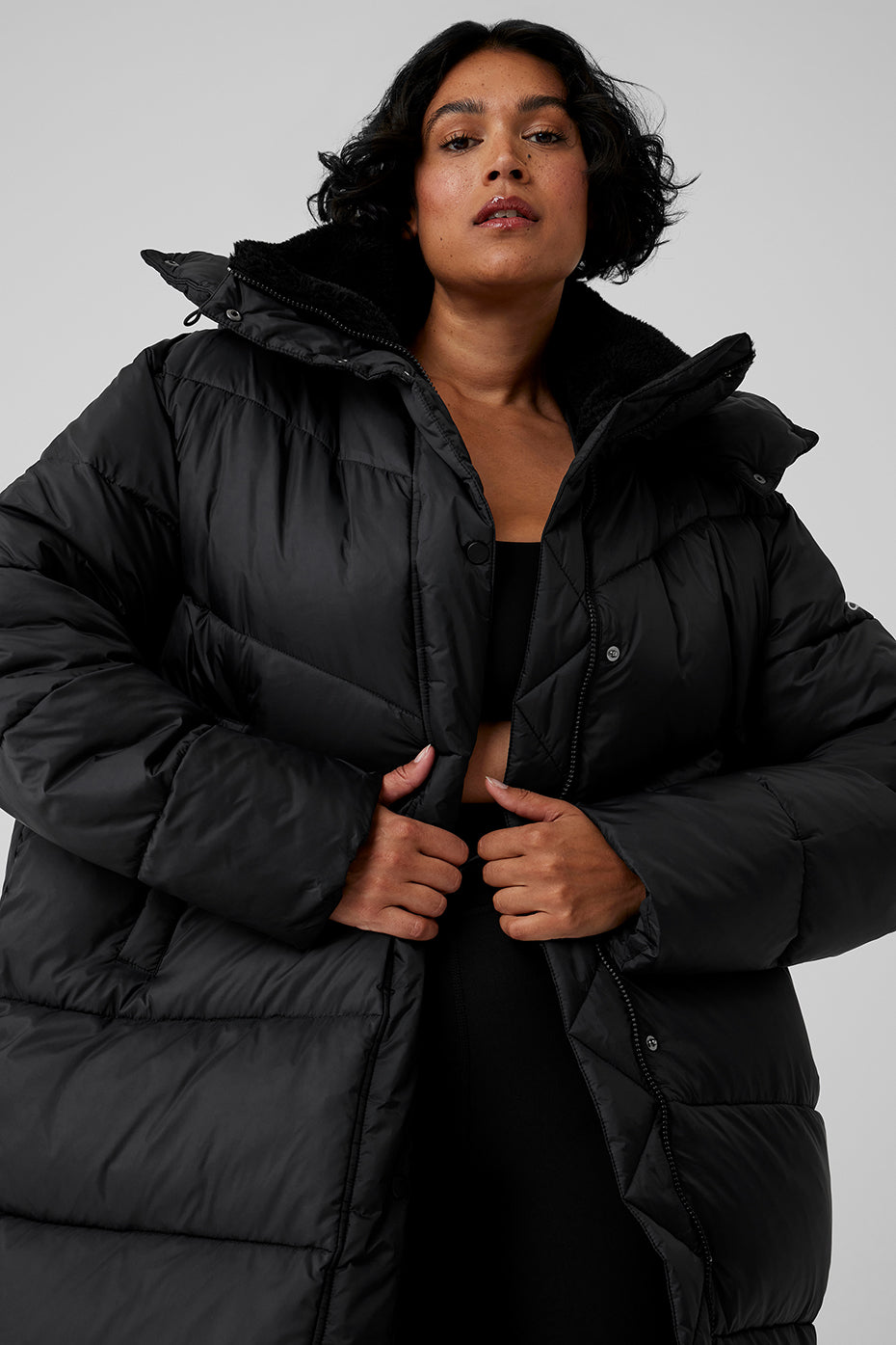 Model wearing oversized black Gold Rush Puffer trench with sherpa-lined collar, perfect for winter outerwear.