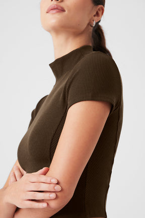 Model showcasing the Wellness Rib Mock Neck Polished Short Sleeve tee, featuring a soft, stretchy fabric and flattering fit.