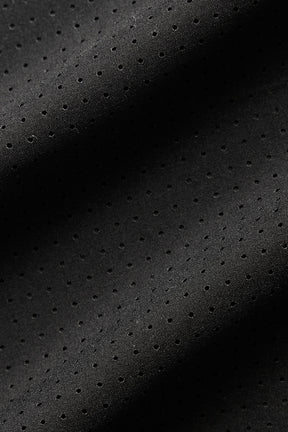 Close-up of lightweight black perforated fabric, ideal for breathable and stylish apparel like the Mesh Cropped Mirage Tee.