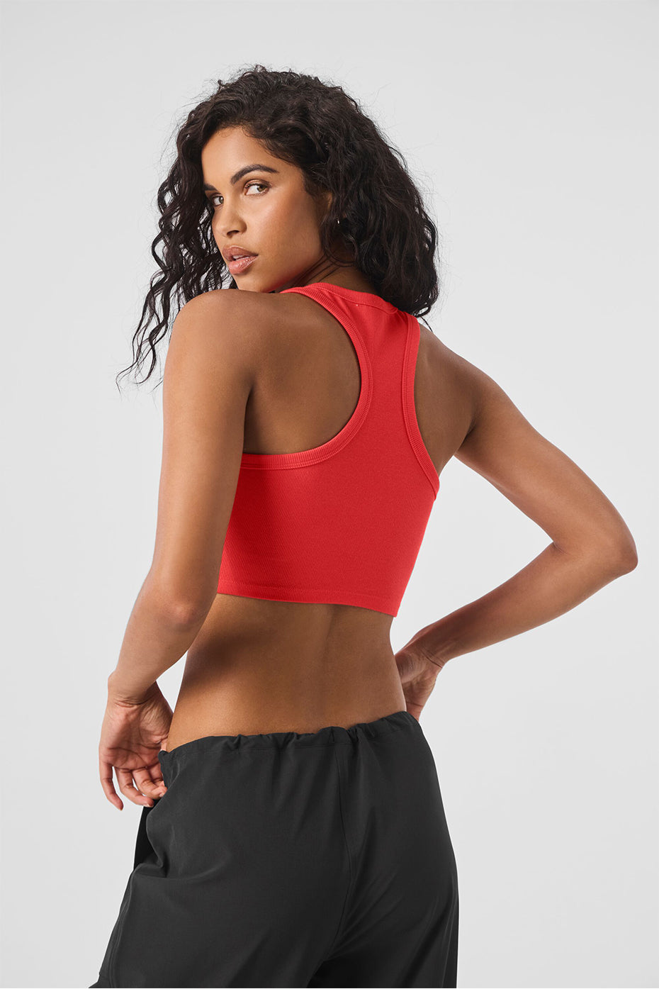 Model wearing red Aspire Tank top showing back view with casual ribbing and cropped design.