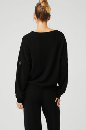 Back view of a woman wearing a black Cashmere Jet Set V-Neck Pullover with dropped shoulders and ribbed waistband.
