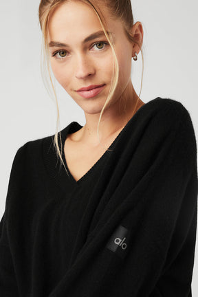 Model wearing a black Cashmere Jet Set V-Neck Pullover with slouchy fit and branded detail on the sleeve.