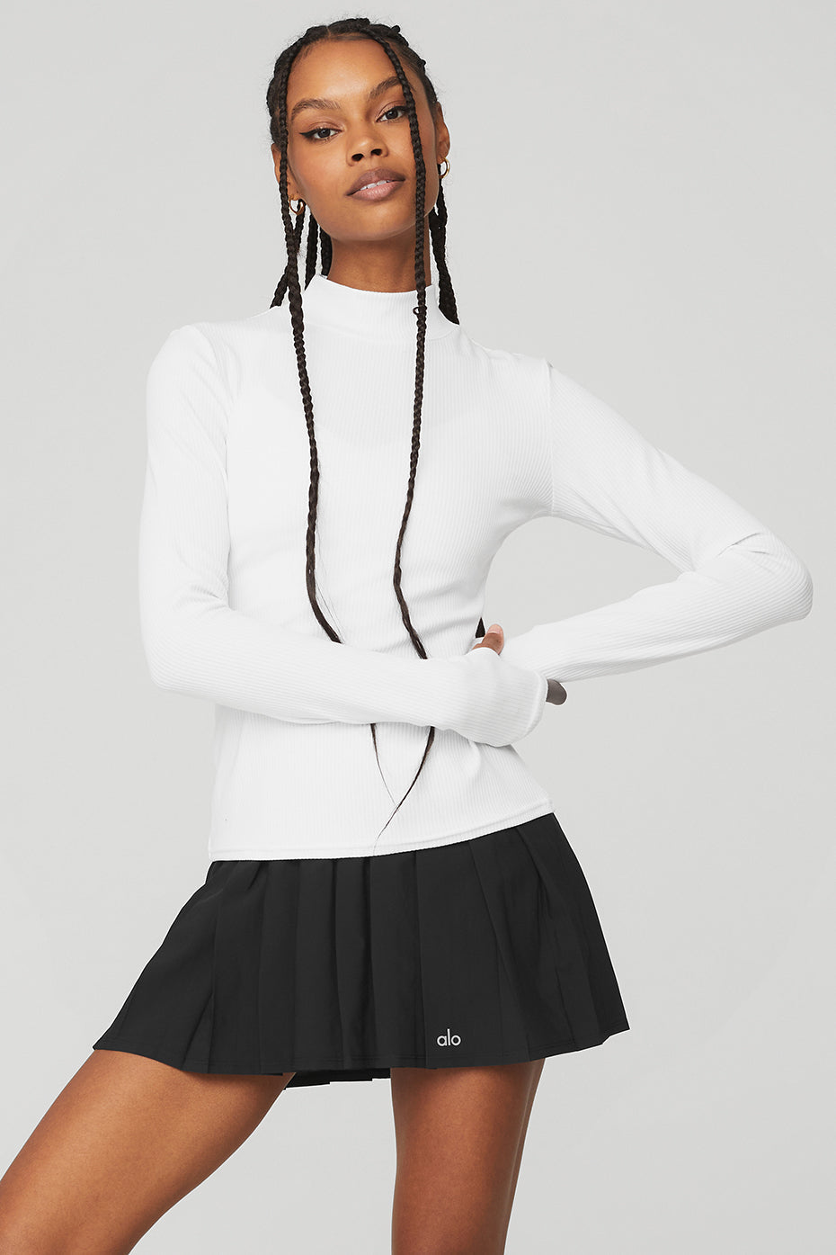 Wellness Rib Mock Neck Long Sleeve in white, paired with a black pleated skirt for a stylish and comfy layered look.