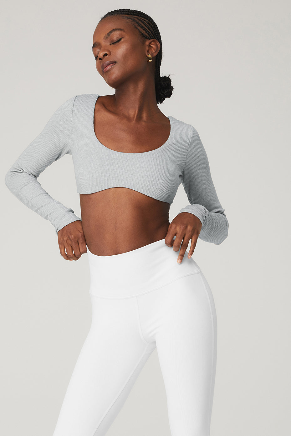 Model showcasing a ribbed defined long sleeve bra with removable cups and flared leggings in wellness ribbed fabric.