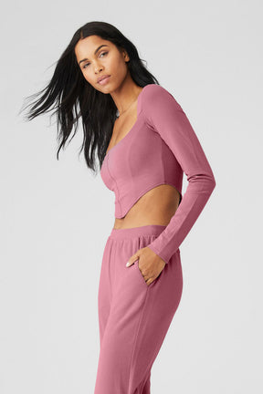 Model wearing ALO Softsculpt Long Sleeve crop top with long sleeves and sweetheart neckline in soft micro French terry fabric.