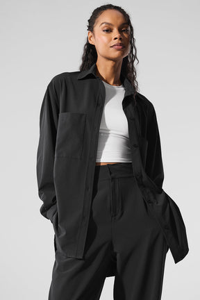 Model wearing the Dreamscape Button Down Long Sleeve shirt in black with front pockets and oversized fit.