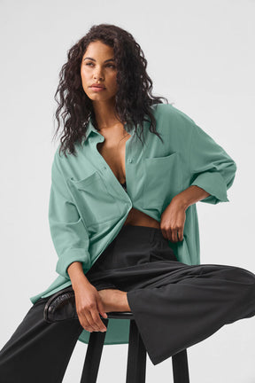 Model wearing the Dreamscape Button Down Long Sleeve shirt in mint green with high-waist trousers, showcasing a stylish oversized look.
