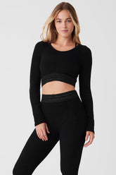 Model wearing Seamless Luxe Terry Cuddle Coverup, a stylish and cozy black crop top paired with matching leggings.