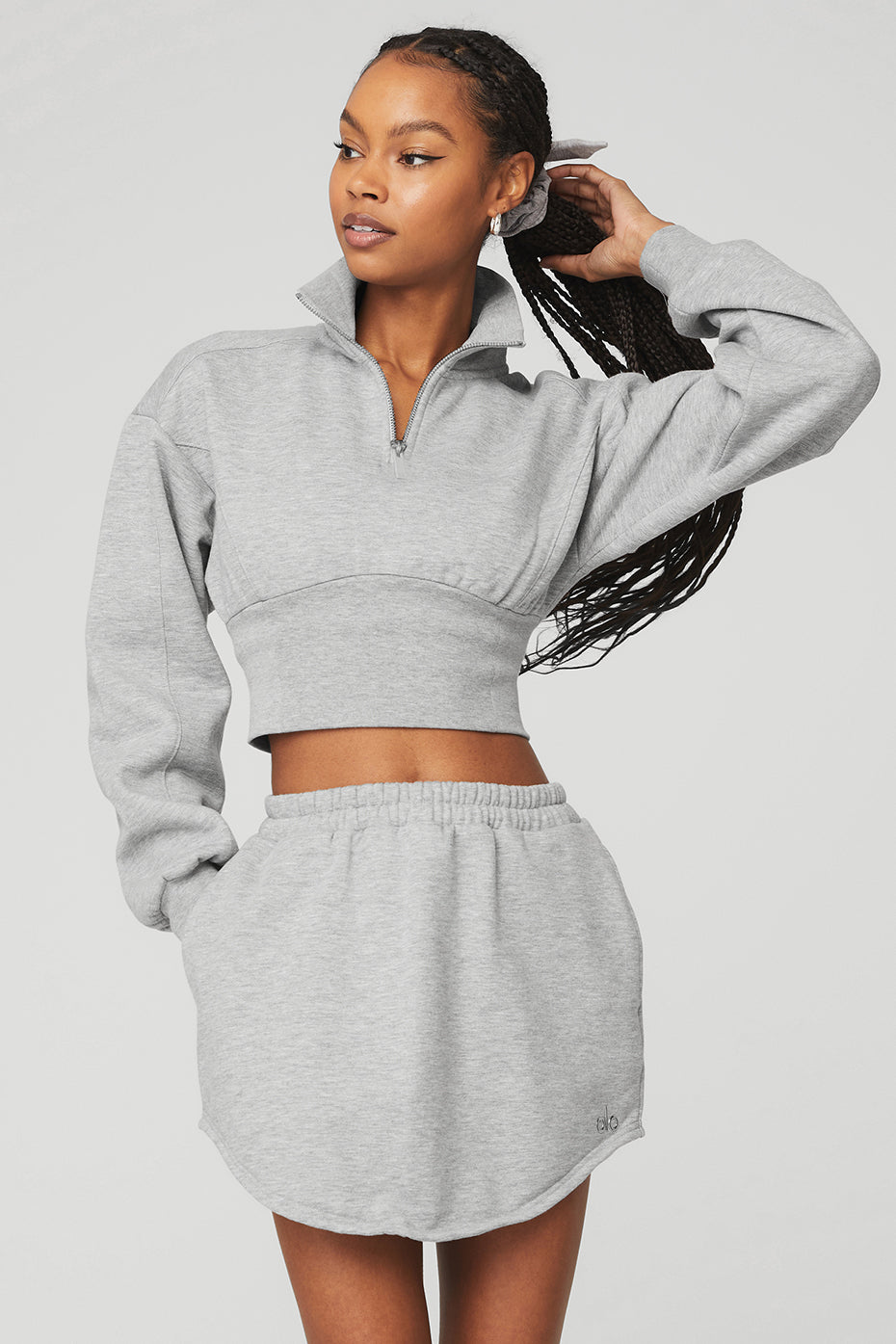 Model wearing a gray Vixen Fleece 1/4 Zip pullover with matching skirt, showcasing a stylish and flirty 90s-inspired outfit.