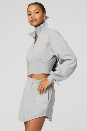 Model wearing Vixen Fleece 1/4 Zip pullover in gray, showcasing a stylish cropped design and high neck.