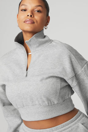 Model wearing Vixen Fleece 1/4 Zip pullover in grey, showcasing its cropped design and high neck for cool weather.