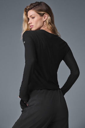 Model wearing Ribbed Sea Coast Long Sleeve shirt in black, showcasing its soft fabric and ribbed design.